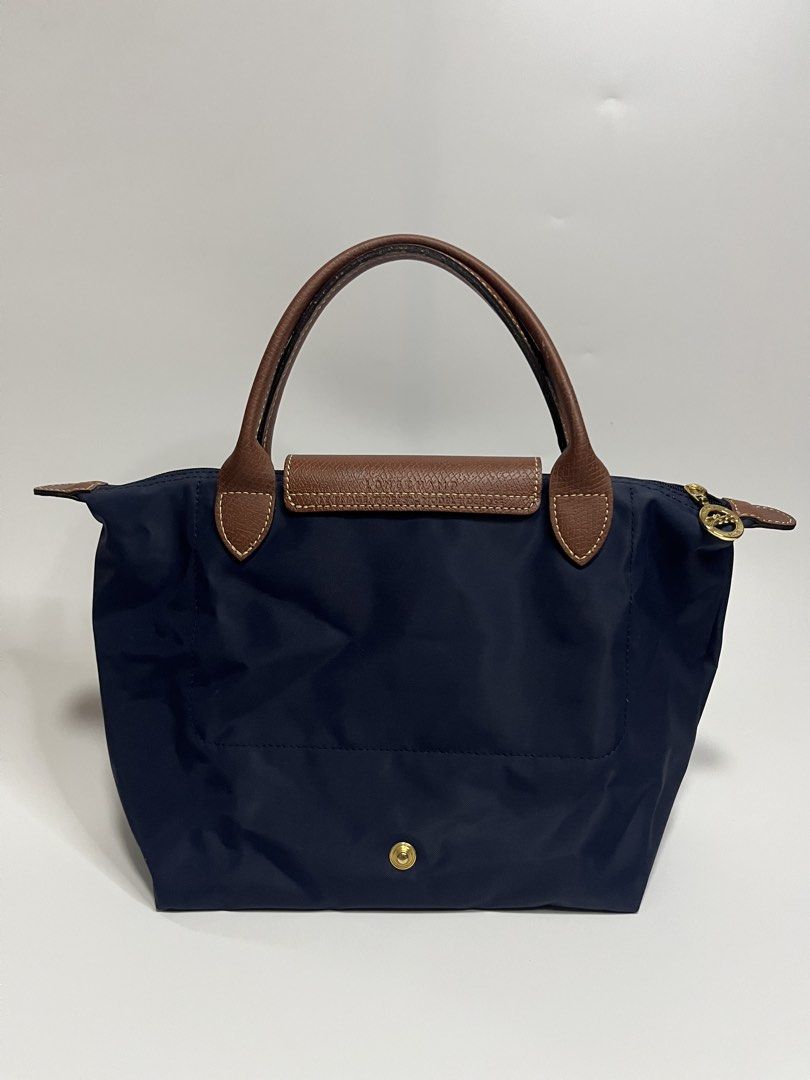 Longchamp Le Pliage Neo Top Handle Bag Navy Blue (Category: Luxury Bags & Wallets) located in Manila. Submitted by niandv (Listing ID 1451851630, Image 2). Description: - Navy blue Longchamp Le Pliage Neo bag - Medium size - Genuine leather handles and trim - Elegant gold hardware - Secure zipper closure with snap button flap - Ideal for everyday use - Ample interior space.