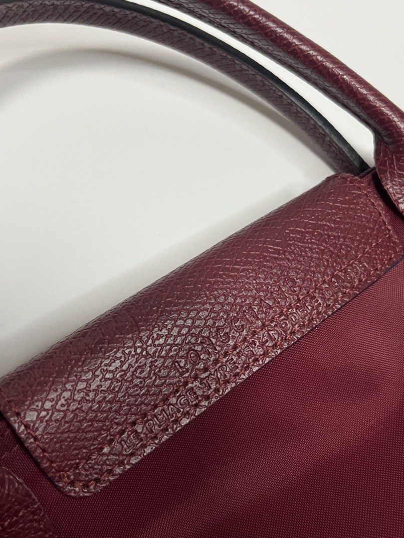 Longchamp Le Pliage Tote Bag Burgundy (Category: Luxury Bags & Wallets) located in Manila. Submitted by niandv (Listing ID 1451850846, Image 3). Description: - Authentic Longchamp Le Pliage tote bag - Color: Burgundy - Material: Nylon body with leather handles and trim - Iconic horse logo embroidery - Interior: Main compartment and small pocket - Origin: Made in France - Ideal for everyday essentials.