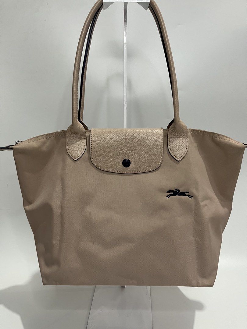Longchamp Le Pliage Tote Bag Beige (Category: Luxury Bags & Wallets) located in Manila. Submitted by niandv (Listing ID 1451852266, Image 1). Description: - Classic Longchamp tote bag - Color: Beige nylon with tan leather trim and handles - Iconic horse logo detail - Secure closure: Zipper with snap-button flap - Spacious interior, ideal for everyday use - Versatile and can fit a lot.