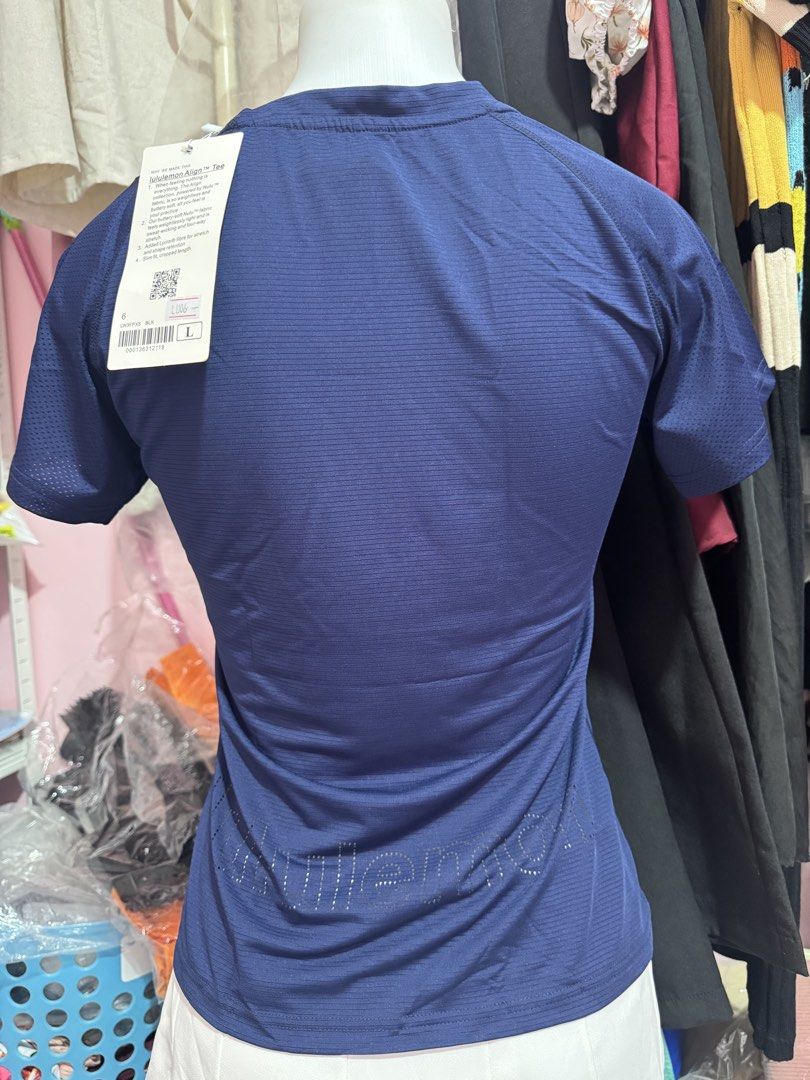 Lululemon Athletic T-shirt - Various Colors (Category: Activewear) located in San Miguel. Submitted by meseszy (Listing ID 1451699347, Image 3). Description: - Brand: Lululemon - Style: Breathable athletic t-shirt - Features: Short sleeves, crew neck, subtle striped texture, Lululemon logo - Back Detail: Lululemon wordmark cut out - Versatile: Ideal for workouts or casual wear - Available Colors: Navy, Lavender, Coral, Light Blue.