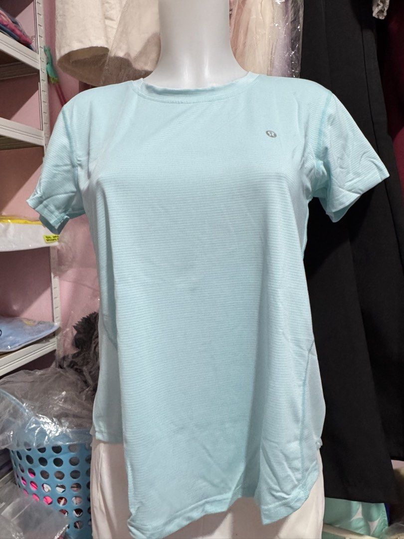 Lululemon Light Blue Athletic T-Shirt (Category: Activewear) located in San Miguel. Submitted by meseszy (Listing ID 1451701723, Image 2). Description: - Light blue Lululemon athletic t-shirt - Short sleeves and crew neck - Subtle textured fabric - Split hem detail on the back - Lululemon logo printed across the upper back - Ideal for workouts or casual wear.