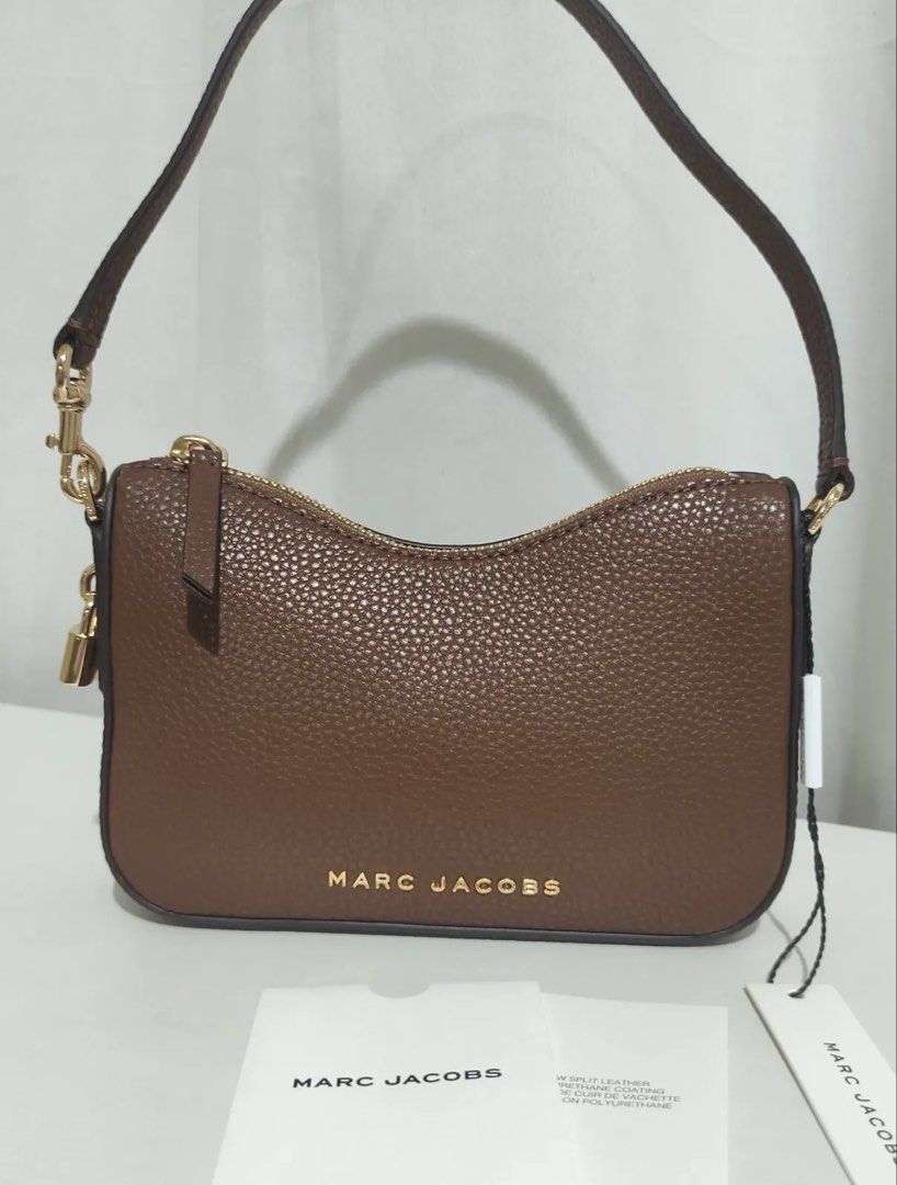 Marc Jacobs Brown Mini Drifter (Category: Luxury Bags & Wallets) located in Las Pinas. Submitted by tanmaine (Listing ID 1451712792, Image 1). Description: - Brand: Marc Jacobs - Material: Brown pebbled leather - Closure: Gold-tone zipper - Features: Cute mini padlock charm - Strap: Adjustable - Condition: Brand new with original tags and authenticity card - Versatile: Ideal for everyday use or evening outings.