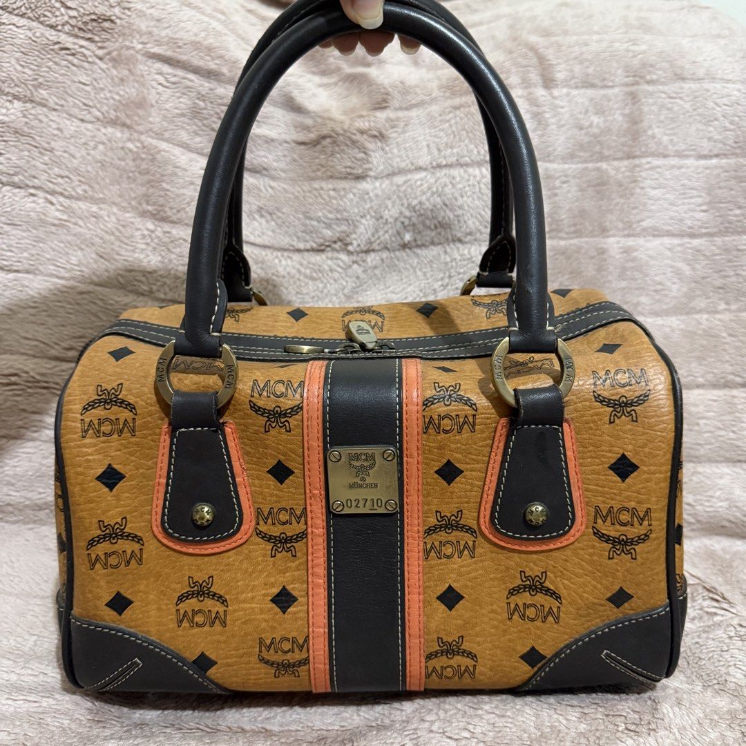 MCM Monogram Boston Bag (Category: Luxury Bags & Wallets) located in Bulacan. Submitted by trendsettersquad (Listing ID 1451754395, Image 1). Description: 🏷️ Item Code: BW05 👜 Brand: MCM Boston bag in the iconic Cognac Visetos monogram 📏 Dimensions: 11 × 7 × 7 in. ✨ Condition: Handles are firm, clean, and free from cracks or peeling. Clean inside and out. Structure remains sturdy and holds its shape well. Minor surface marks consistent with no