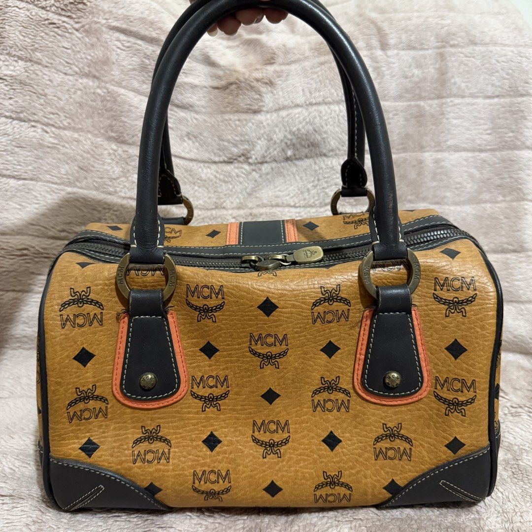 MCM Monogram Boston Bag (Category: Luxury Bags & Wallets) located in Bulacan. Submitted by trendsettersquad (Listing ID 1451754395, Image 2). Description: 🏷️ Item Code: BW05 👜 Brand: MCM Boston bag in the iconic Cognac Visetos monogram 📏 Dimensions: 11 × 7 × 7 in. ✨ Condition: Handles are firm, clean, and free from cracks or peeling. Clean inside and out. Structure remains sturdy and holds its shape well. Minor surface marks consistent with no