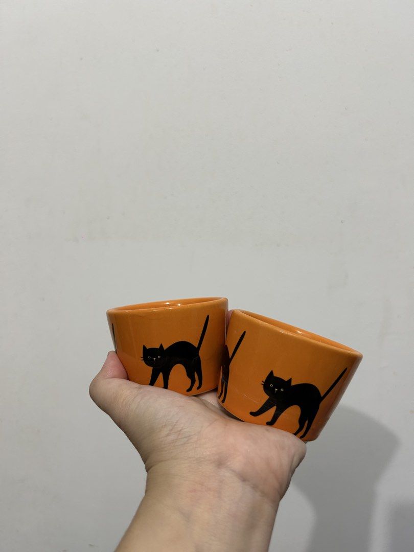 Orange Black Cat Ceramic Cups Set of 2 (Category: Coffee & Tea Tableware) located in Makati City. Submitted by michellecollado07 (Listing ID 1451892282, Image 1). Description: - Set of 2 cute orange cups with black cat design - Perfect for Halloween or cat lovers - Dishwasher, oven, and microwave safe - Ideal for coffee, tea, or small snacks - Made in China.
