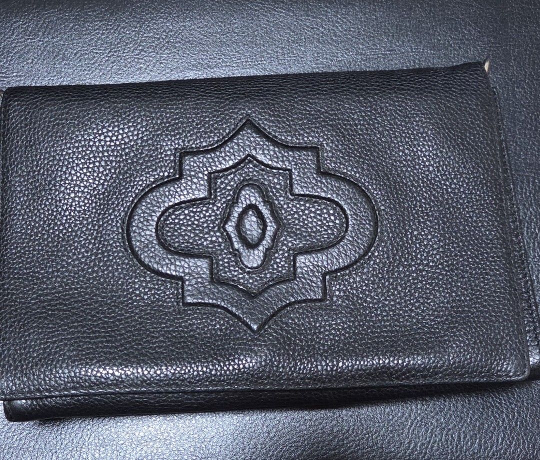 ORYANI Black Leather (Category: Clutches) located in Manila. Submitted by daddyhunt99 (Listing ID 1451767160, Image 1). Description: - Stylish black leather clutch - Unique embossed pattern on front flap - Secure magnetic snap closure - Multiple interior compartments for organization - Interior zippered pocket - Geometric pattern lining - Subtle 'ANNY' brand embossing inside.