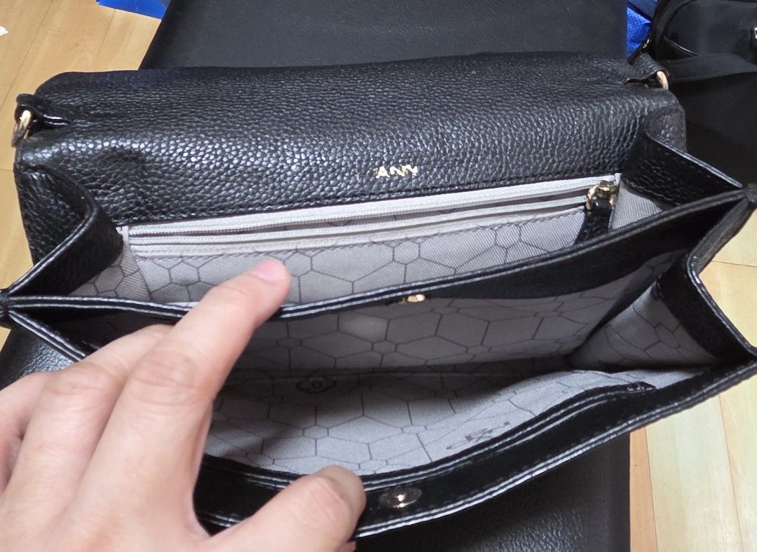 ORYANI Black Leather (Category: Clutches) located in Manila. Submitted by daddyhunt99 (Listing ID 1451767160, Image 3). Description: - Stylish black leather clutch - Unique embossed pattern on front flap - Secure magnetic snap closure - Multiple interior compartments for organization - Interior zippered pocket - Geometric pattern lining - Subtle 'ANNY' brand embossing inside.
