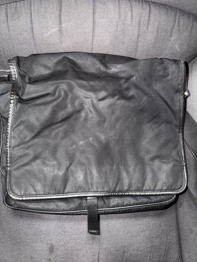 Prada Nylon Messenger Bag (Category: Luxury Bags & Wallets) located in Cainta. Submitted by emcyo (Listing ID 1451721278, Image 1). Description: - Authentic Prada messenger bag - Durable nylon material with elegant leather trim - Secure buckle closure on the front flap - Interior zippered pocket for essentials - Shows some signs of wear on exterior fabric, adding character - Ideal for everyday carry and versatile use - lost hardlock “Kindly lower
