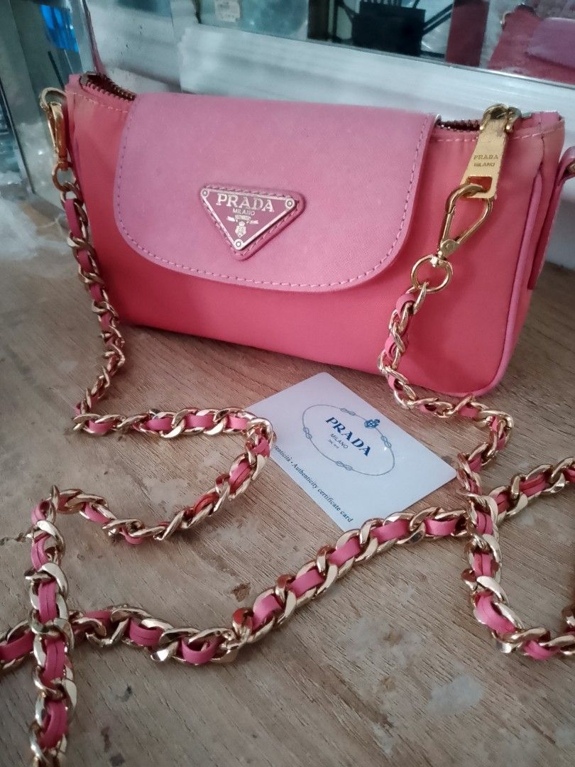 Prada Pink Nylon Chain Shoulder Bag (Category: Luxury Bags & Wallets) located in Carmen. Submitted by badkiss_coffee26 (Listing ID 1451852916, Image 1). Description: - Authentic Prada bag in a lovely pink shade. - Durable nylon material with a chic leather flap. - Elegant gold chain strap accented with pink leather. - Comes with original authenticity card. - Versatile for casual day trips or sophisticated evenings. - Secure zipper closure. - Inte