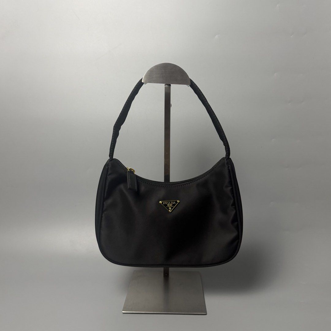 Prada re-edition (Category: Luxury Bags & Wallets) located in Malasiqui. Submitted by fosh0fosh0 (Listing ID 1451760371, Image 1). Description: - Stylish black bag - Durable nylon-like material - Shiny gold zipper pull with logo - Black beaded zipper detail - Ideal for everyday use.