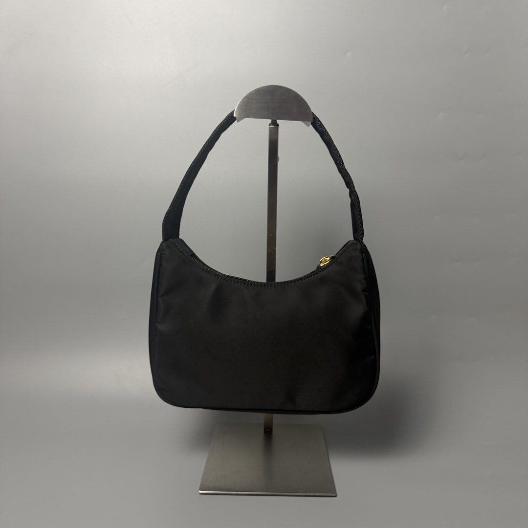 Prada re-edition (Category: Luxury Bags & Wallets) located in Malasiqui. Submitted by fosh0fosh0 (Listing ID 1451760371, Image 2). Description: - Stylish black bag - Durable nylon-like material - Shiny gold zipper pull with logo - Black beaded zipper detail - Ideal for everyday use.