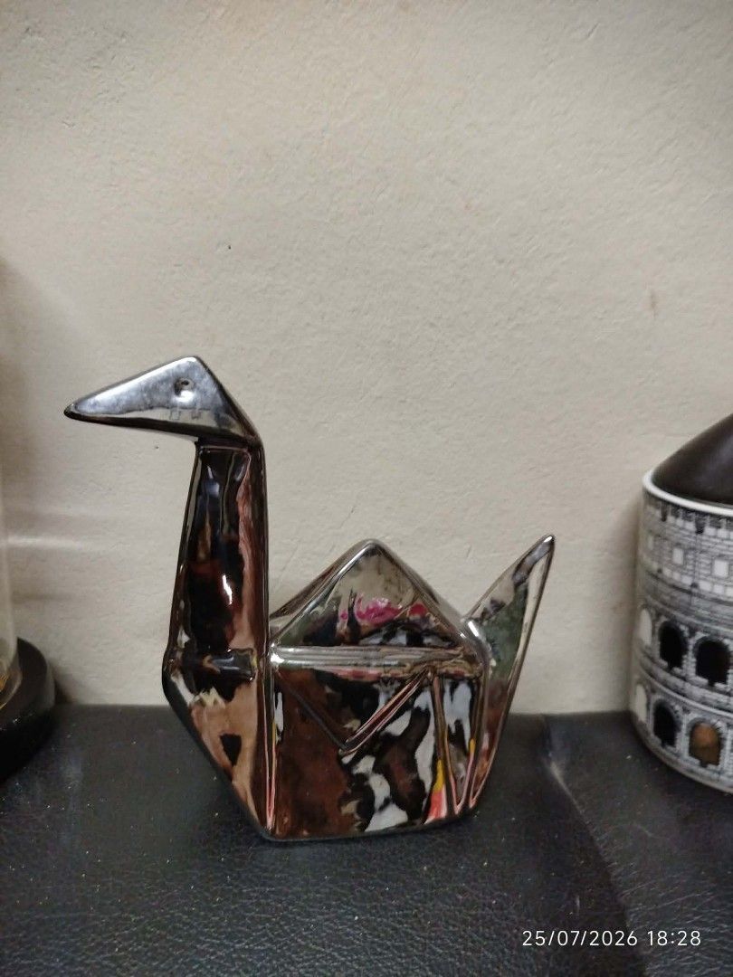 Shiny Silver Origami Crane Decorative Figurine (Category: Other Home Decor) located in Quezon City. Submitted by chadrison (Listing ID 1451825271, Image 1). Description: - Shiny silver decorative piece - Shaped like an origami crane - Polished, reflective surface - Approx. dimensions: 15cm (L) x 10cm (H) - Ideal for shelf or desk display - Adds a modern, artistic touch to your space - Unique home decor item.