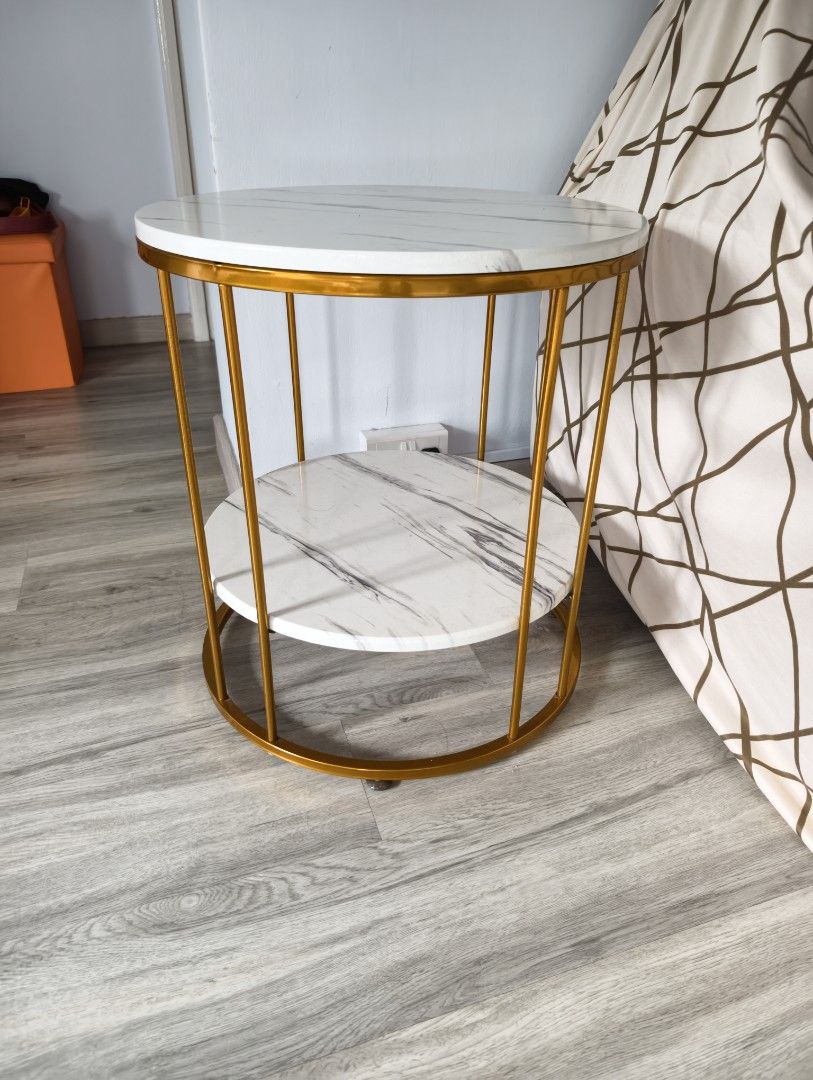 Side Table (Category: Tables & Sets) located in Singapore. Submitted by yzzih (Listing ID 1451813758, Image 1). Description: - Two-tier round side table - White marble effect tops - Gold metal frame - Ideal for living room or bedroom - Compact size, fits most spaces - Easy to clean surfaces - Sturdy construction.