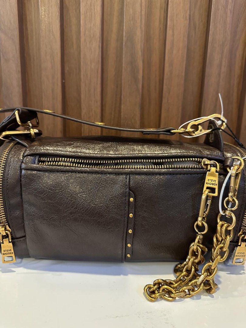 Steve Madden Brown Barrel Bag with Gold Hardware (Category: Luxury Bags & Wallets) located in Makati City. Submitted by sebastiene (Listing ID 1451785834, Image 2). Description: - Cool barrel-shaped bag from Steve Madden - Dark brown color with a textured finish - Stylish gold hardware details (zippers, chain strap accents) - Convenient front pocket - Detachable crossbody strap for versatile wear - Ideal for everyday use or a night out.
