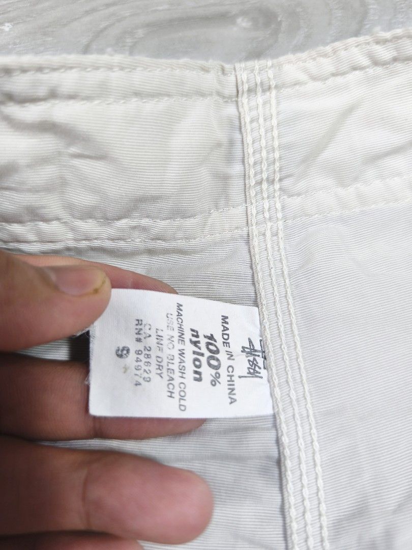 Stussy Board Shorts (Category: Shorts) located in Paranaque City. Submitted by pickersform (Listing ID 1451806963, Image 3). Description: - White Stussy board shorts size Small waistline 30-32 / Length 19 / opening 10 - Made from 100% nylon - Drawstring waist for adjustable fit - Back pocket with button closure - Quick-drying material - Ideal for beach, pool, or casual wear.