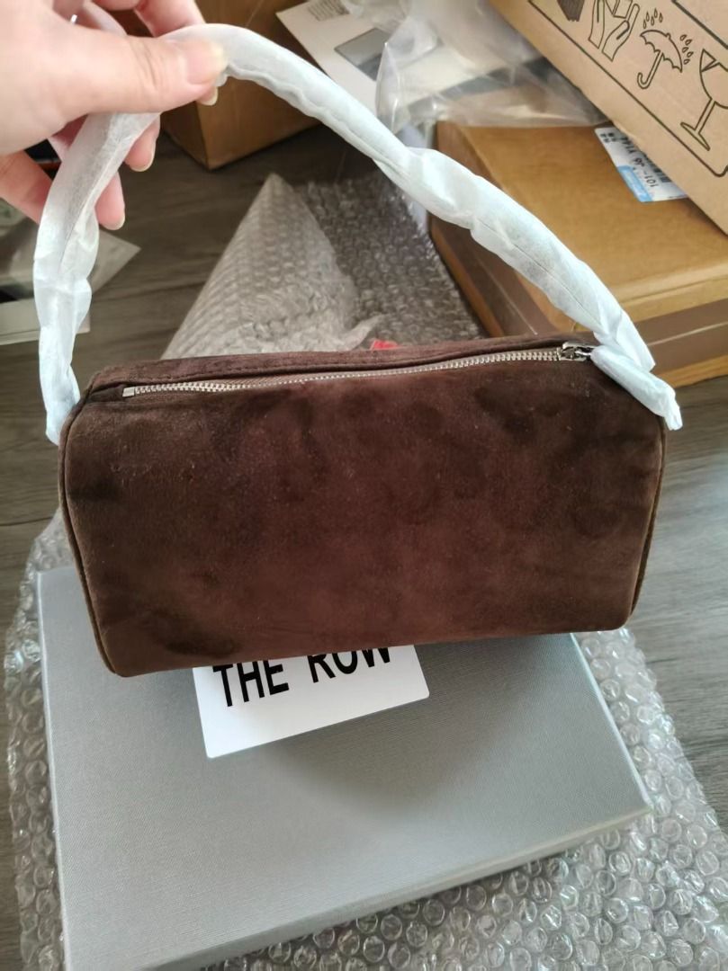 The Row Suede Bag (Category: Luxury Bags & Wallets) located in Quezon City. Submitted by shilpamour86508 (Listing ID 1451771413, Image 1). Description: - Brand: The Row - Color: Brown - Material: Suede - Closure: Zipper - Handle: Small top handle - Interior details: The Row logo, 'Made in Italy' - Includes: Dust bag, Original box - Ideal for: Everyday use.