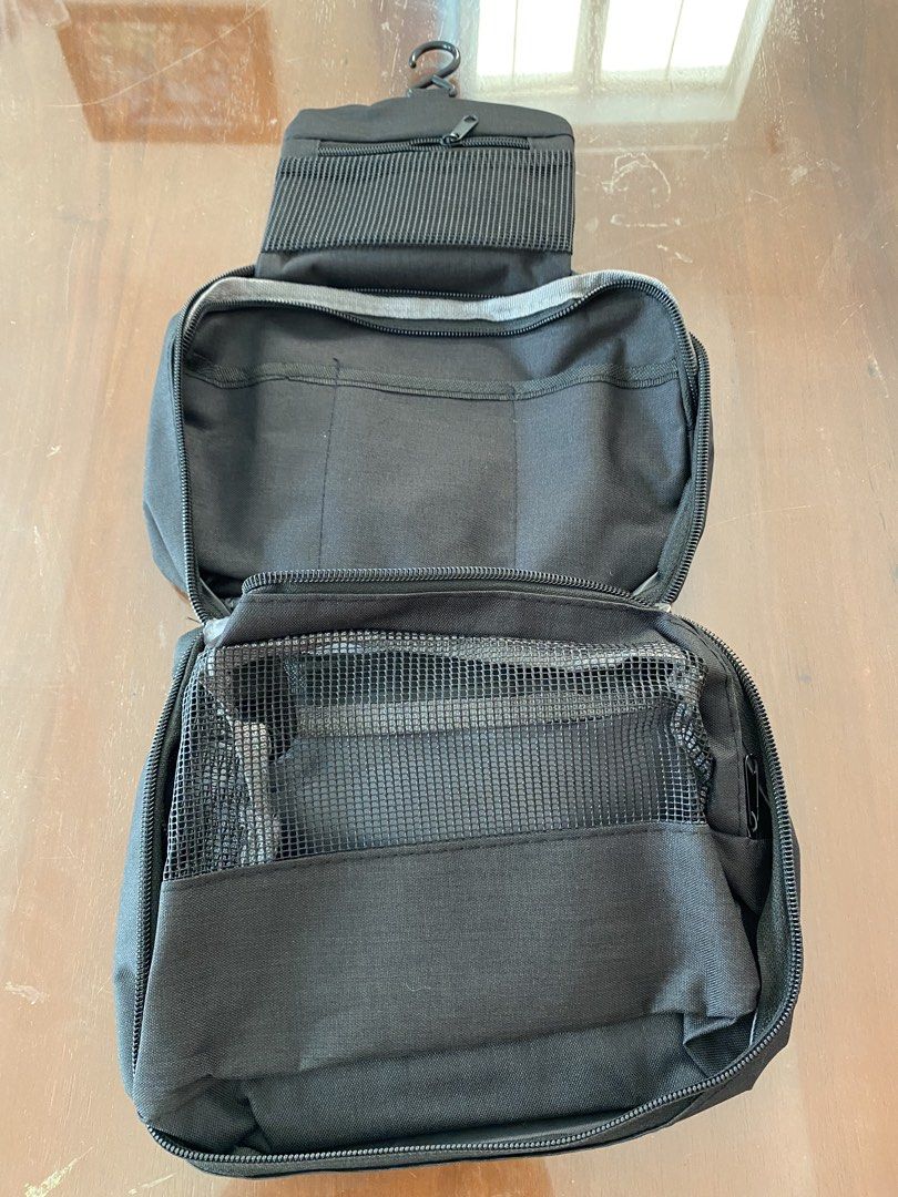 Travel Toiletry Bag with Hook - Black Polyester (Category: Purses & Pouches) located in Bacoor. Submitted by gracemc2024 (Listing ID 1451722594, Image 2). Description: - Durable black toiletry bag perfect for travel. - Made from sturdy 300D polyester material. - Multiple compartments for organized storage. - Includes a convenient mesh pocket. - Features a built-in hook for hanging. - Compact and easy to pack when folded..