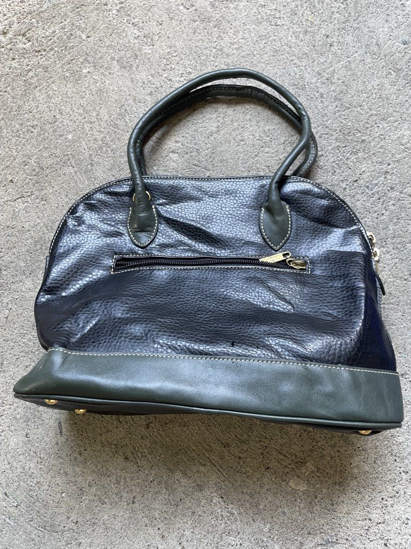 Vintage Black & Green Leather Dome Handbag (Category: Luxury Bags & Wallets) located in Siniloan. Submitted by rethr1ft (Listing ID 1451752876, Image 2). Description: - Classic dome handbag style - Black pebbled leather with elegant green accents - Polished gold-tone hardware and signature emblem - Secure top zipper closure - Convenient back pocket - Interior zippered compartment for organization - Four metal feet to protect the base - Ideal for 