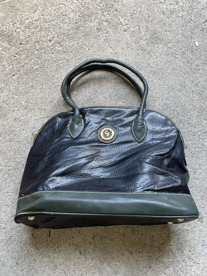 Vintage Black & Green Leather Dome Handbag (Category: Luxury Bags & Wallets) located in Siniloan. Submitted by rethr1ft (Listing ID 1451752876, Image 1). Description: - Classic dome handbag style - Black pebbled leather with elegant green accents - Polished gold-tone hardware and signature emblem - Secure top zipper closure - Convenient back pocket - Interior zippered compartment for organization - Four metal feet to protect the base - Ideal for 