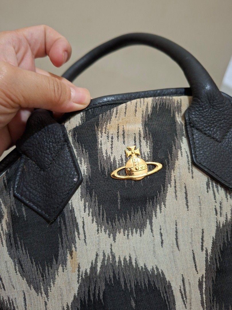 Vivienne Westwood Leopard Print Handbag (Category: Luxury Bags & Wallets) located in General Trias. Submitted by thriftergurl (Listing ID 1451817928, Image 3). Description: - Authentic Vivienne Westwood handbag - Eye-catching leopard print - Black leather handles and trim - Signature gold orb logo on the front - Secure zipper closure - Perfect statement accessory *With Visible stains* *Stored For too long, needs cleaning* can do meet up in bacoor