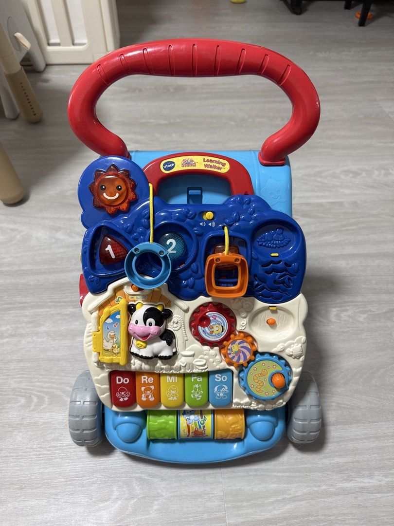 VTech Learning Walker (Category: Infant Playtime) located in Singapore. Submitted by yuxiaojune (Listing ID 1451818313, Image 1). Description: - VTech Learning Walker - Interactive activities to engage your little one - Features a piano keyboard with musical notes and animal sounds - Includes gears, beads, and a flip book - Perfect for babies learning to walk and play - Red handle designed for easy grip.