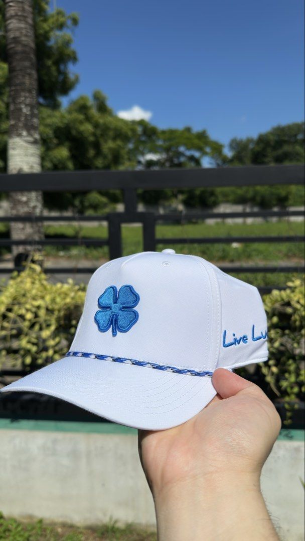 White Black Clover Live Lucky Adjustable Golf Cap Hat (Category: Caps & Hats) located in Dasmarinas. Submitted by valuevibe (Listing ID 1451839790, Image 1). Description: Original Price: Php 2,200 ❌ Sale Price: Php 650 ✅ Brand: Black Clover Condition: Brand New - White golf cap - Blue clover logo - 'Live Lucky' embroidery on the side - Braided rope detail above the brim - Ideal for sunny days, golf, or casual wear - Comfortable fit.
