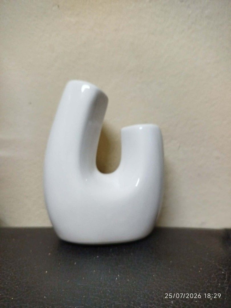 White Ceramic U-Shaped Vase (Category: Vases & Decorative Bowls) located in Quezon City. Submitted by chadrison (Listing ID 1451826075, Image 1). Description: - Unique white ceramic vase - Modern U-shape design - Ideal for small bouquets or single stems - Adds a minimalist touch to any space - Great for dried flowers or standalone decor.