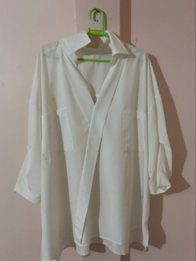 White oversized button-down blouse (Category: Longsleeves) located in Manila. Submitted by mandm.finds (Listing ID 1451847649, Image 1). Description: featuring dual chest patch pockets, a deep open V-neck style collar, and relaxed drop-shoulder sleeves with tab or panel details.