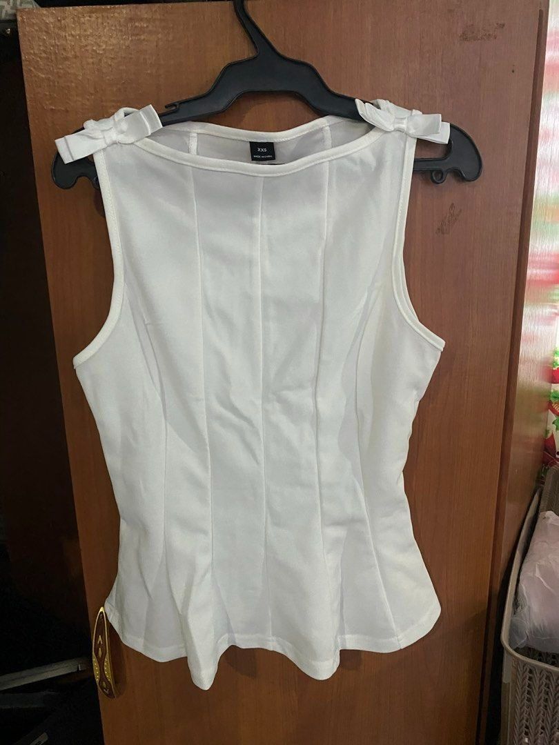 White Sleeveless Top with Bows XSS (Category: Luxury Apparel) located in Davao. Submitted by pickystuff (Listing ID 1451855489, Image 2). Description: - White sleeveless top - Bow details on shoulders - Fitted silhouette - Scoop neckline - Slightly flared hem xxs on tag but fits xs to s.