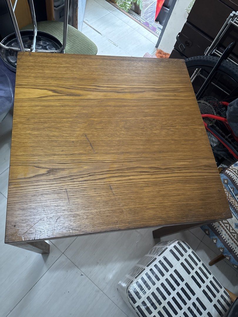 Wooden Square Dining Table for 4 (Category: Tables & Sets) located in Quezon City. Submitted by elektra0111 (Listing ID 1451897595, Image 3). Description: - Solid wood square table - Ideal for small spaces or as a side table - Features attractive wood grain - Sturdy legs for stability - Minor surface scratches from normal use - Still in good, usable condition - Ready for a new home - Dimensions in cm 70x70.