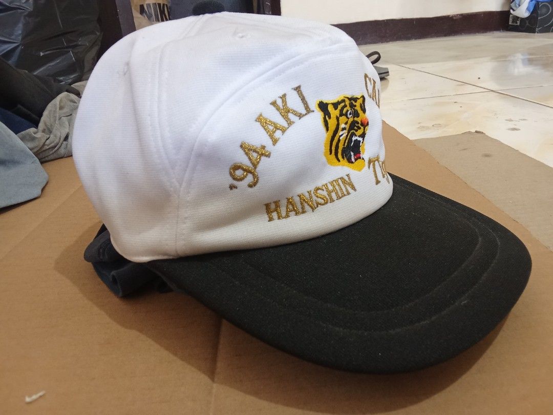 1994 Hanshin Tigers Aki Camp Baseball Cap (Category: Caps & Hats) located in Davao. Submitted by kristian2020 (Listing ID 1451905517, Image 2). Description: - Vintage 1994 Hanshin Tigers cap - Color: White with black brim - Features embroidered tiger logo - 'PRESS' embroidered on the side - Adjustable strap at the back - Ideal for collectors and fans - cap from japan surplus, expect dust dirt at top.