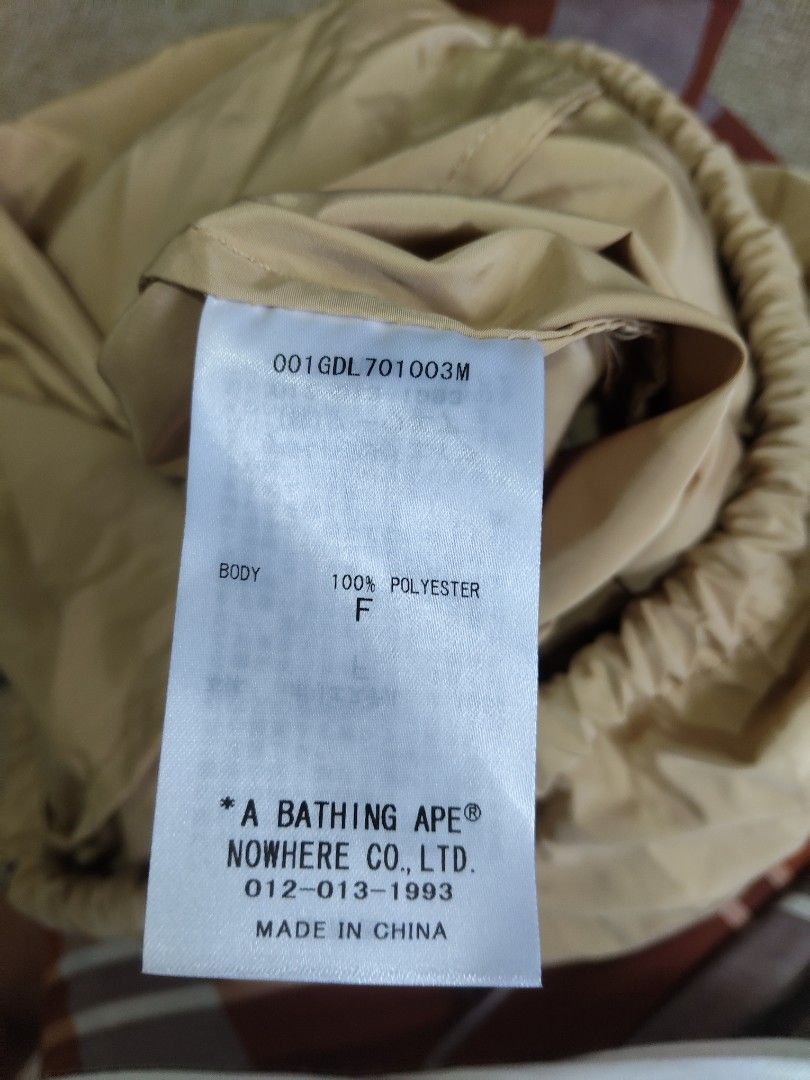 A Bathing Ape BAPE Drawstring Bag (Category: Sling Bags) located in Klang. Submitted by happybundle (Listing ID 1451918995, Image 1). Description: - Authentic A Bathing Ape (BAPE) drawstring bag - Classic tan color with iconic BAPE logo graphic - Made from durable 100% polyester material - Ideal for gym sessions, travel, or everyday carry - Convenient drawstring closure for easy access.