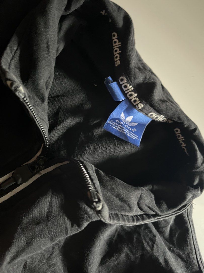 Adidas Zip Up Jacket (Category: Coats, Jackets and Outerwear) located in Santa Ana. Submitted by rlave (Listing ID 1452000313, Image 3). Description: Preloved Adidas Originals black full-zip track jacket, featuring the classic embroidered/printed Trefoil logo on the chest, “adidas” branding repeated along the collar and sleeve trims, and zippered side pockets. Ribbed collar and cuffs, comfortable relaxed fit — great for layering or everyday casua