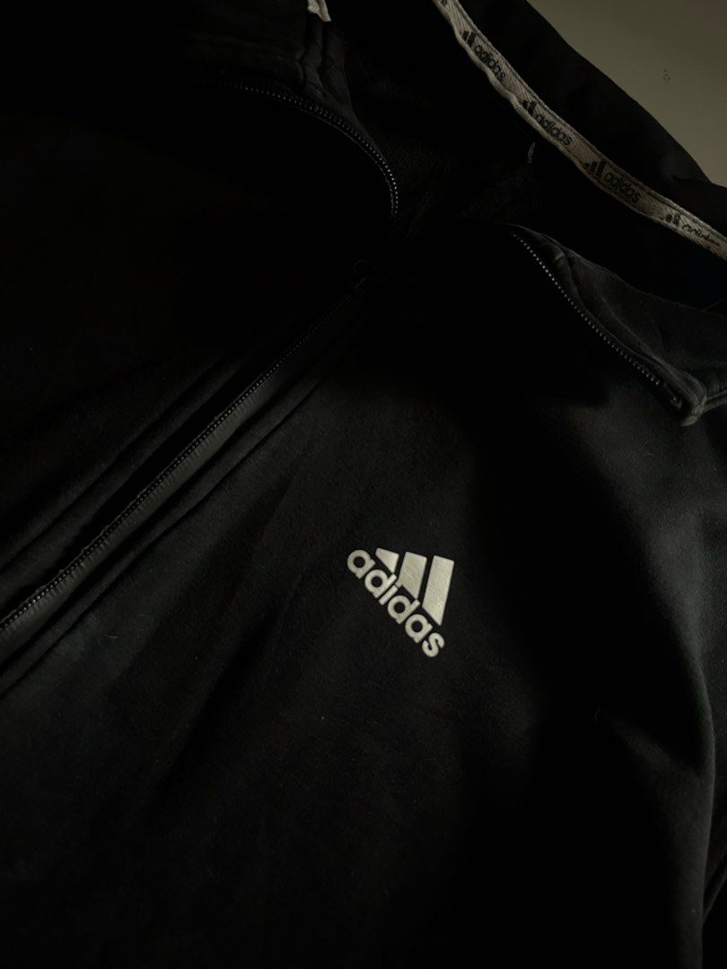 Adidas Zip Up Jacket (Category: Coats, Jackets and Outerwear) located in Santa Ana. Submitted by rlave (Listing ID 1452000729, Image 2). Description: Preloved Adidas black full-zip jacket, featuring the embroidered logo on the chest and a bold printed “adidas” wordmark with 3-Stripes on the sleeve. Ribbed collar, cuffs, and hem, zippered side pockets, comfortable relaxed fit — great for layering or everyday casual wear. Item is in good preloved c