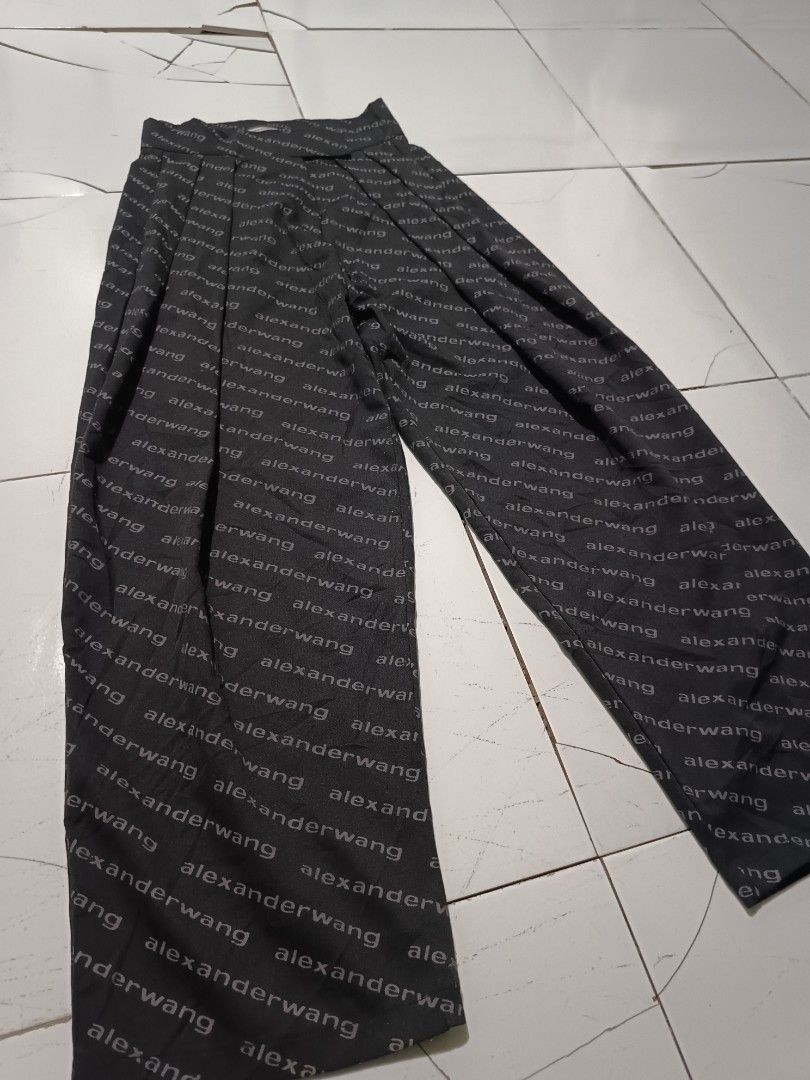 Alexander Wang All Over Logo Pants (Category: Other Bottoms) located in Barotac Nuevo. Submitted by gray101 (Listing ID 1452051485, Image 2). Description: - Alexander Wang pants with all-over logo print - Color: Black with grey text - Material: 100% Cotton body, 100% Polyester trim - Origin: Made in Turkey - Unique features: Pleated front, velcro closure - A bold statement piece for your wardrobe - Reflector script .