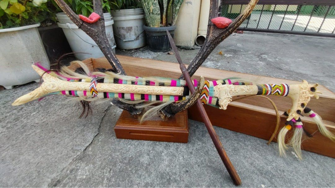 Antique Tribal Knife (Category: Vintage Collectibles) located in Cainta. Submitted by danica010314 (Listing ID 1452036915, Image 1). Description: This item is a traditional Dayak Mandau sword from Borneo, featuring a detailed carved hilt made of deer horn and a sheath adorned with colorful fabrics and goat hair.- Unique decorative knife set - Features carved bone handles - Colorful woven accents - Sharp blades with a rustic finish - Ideal for col