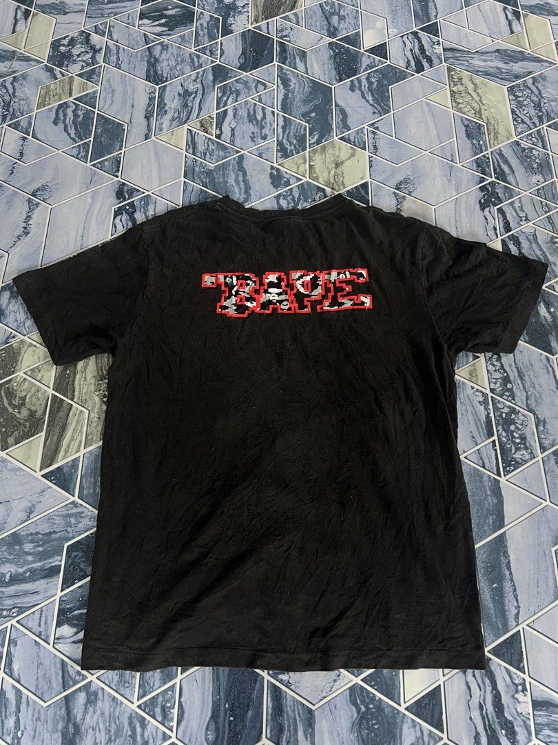 BAPE Pixel Ape & "BAPE" Logo Black T-Shirt (Category: Tshirts & Polo Shirts ) located in Manila. Submitted by thrifttolive (Listing ID 1451962282, Image 2). Description: - Authentic BAPE T-shirt - Size: Medium (M) - Front: Pixelated Ape Head graphic with 'BAPE' text - Back: 'BAPE' text in camouflage pattern - Sleeve: Small BAPE tag detail -Dimes:21x27 -Good condition -No issues .