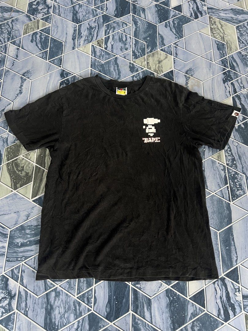BAPE Pixel Ape & "BAPE" Logo Black T-Shirt (Category: Tshirts & Polo Shirts ) located in Manila. Submitted by thrifttolive (Listing ID 1451962282, Image 1). Description: - Authentic BAPE T-shirt - Size: Medium (M) - Front: Pixelated Ape Head graphic with 'BAPE' text - Back: 'BAPE' text in camouflage pattern - Sleeve: Small BAPE tag detail -Dimes:21x27 -Good condition -No issues .