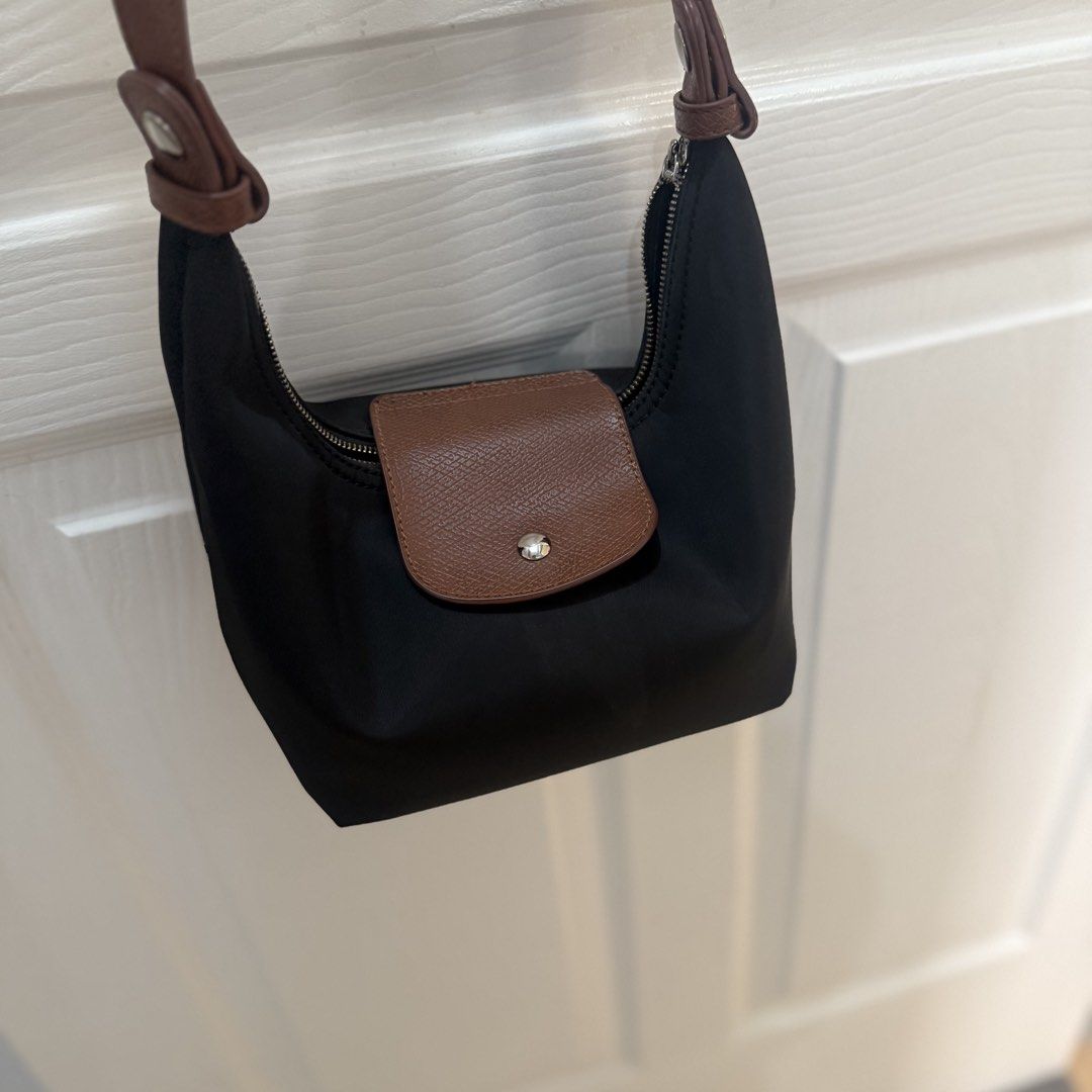 Black Nylon Shoulder Bag with Brown Leather Trim (Category: Shoulder Bags) located in Quezon City. Submitted by _seyer (Listing ID 1451971247, Image 2). Description: - Cute black nylon shoulder bag - Brown leather accents on flap and strap - Zipper closure - Black lining inside - Great for everyday use - Compact and easy to carry.
