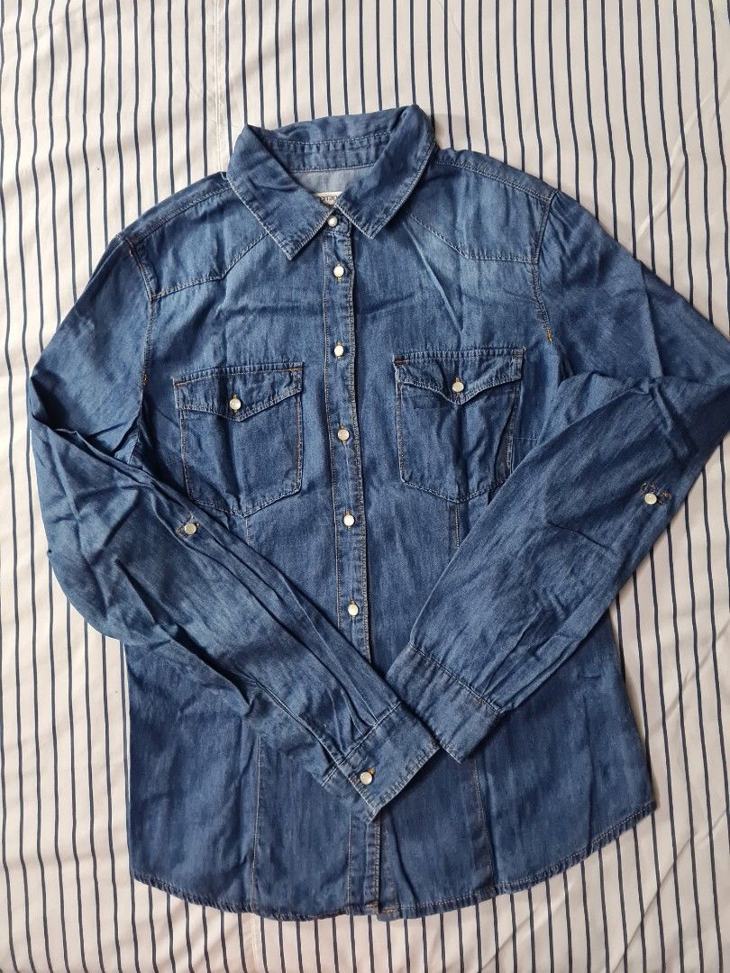 Blue Denim Long Sleeve Shirt with Pockets (Category: Longsleeves) located in Batangas. Submitted by mariroz (Listing ID 1451943553, Image 1). Description: - Classic blue denim shirt - Long sleeves with button cuffs - Two chest pockets with button closures - Button-up front - Versatile for dressing up or down.