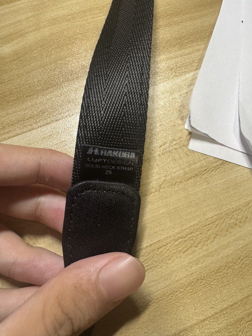 Camera strap (Category: Camera Bags & Carriers) located in Singapore. Submitted by goldengem_96c3b1 (Listing ID 1451960578, Image 2). Description: - HAKUBA Luftdesign Solid 25 Camera Neck Strap - Color: Black - Material: Polyester, Nylon, PVC - Strap Width: 25mm - Total Length: 1570mm - Features: Non-slip grip on the back - Condition: Comes in original packaging Only a small grip scratched off at the back (pic 6).