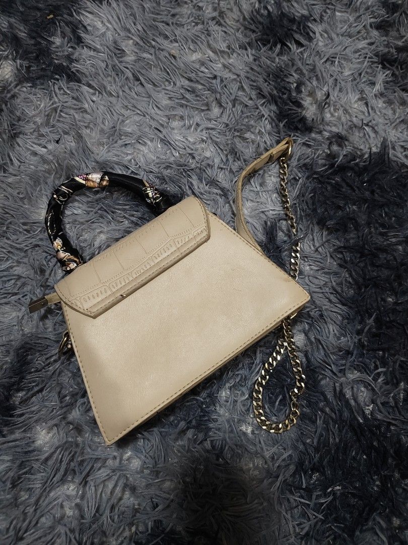 Charles & Keith Beige Croc Embossed Triangle Handbag with Scarf (Category: Luxury Bags & Wallets) located in Manila. Submitted by querobin11 (Listing ID 1452029337, Image 2). Description: - Stylish beige triangle handbag - Elegant croc-embossed flap - Adorable scarf tied to the handle - Includes a chic gold chain strap - Compact size, ideal for carrying essentials - Interior and exterior are clean RFS DECLUTTERING .