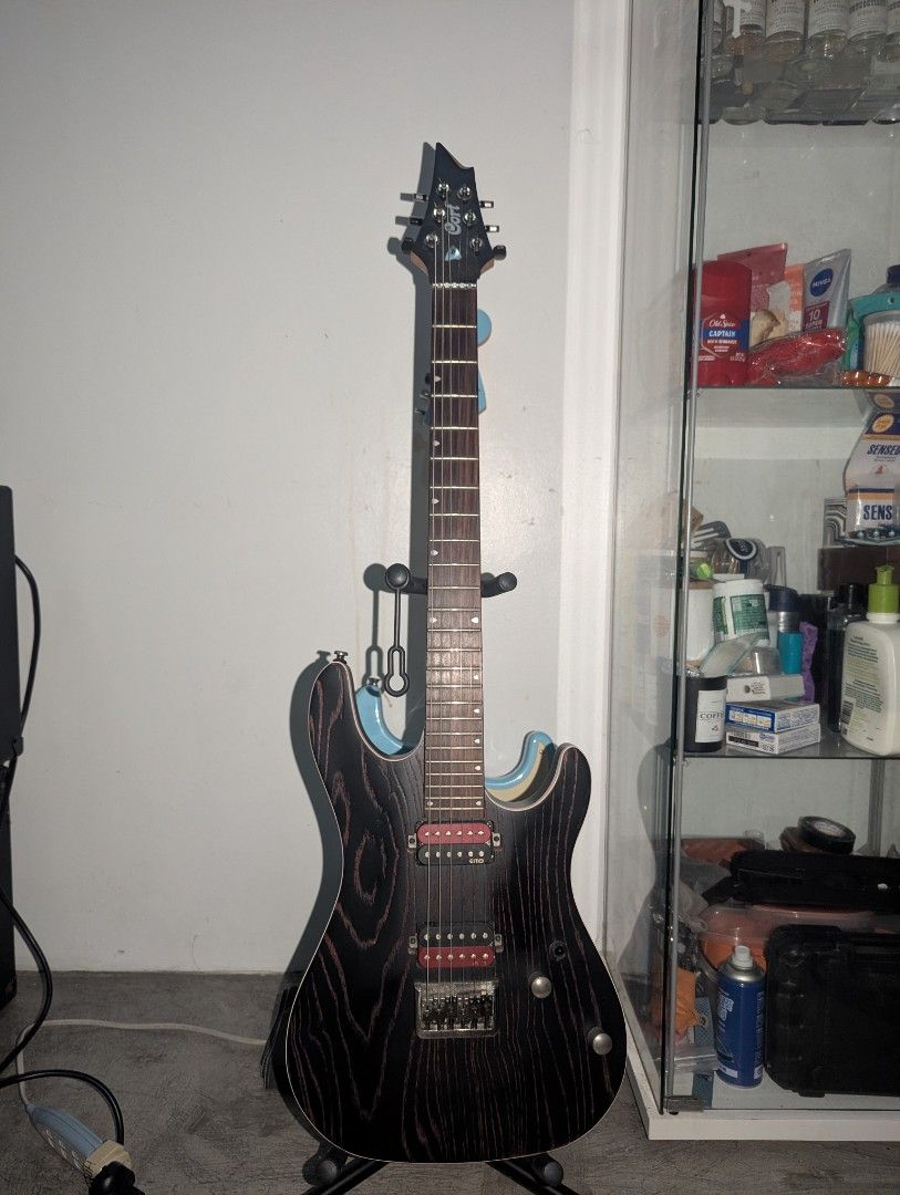 Cort Electric Guitar - Etched Black with Red (Category: Musical Instruments) located in Angeles City. Submitted by jakki_19 (Listing ID 1451901000, Image 1). Description: - Sleek black electric guitar with striking red wood grain streaks. - Equipped with powerful dual humbucker pickups for a robust sound. - Ideal for rock and metal genres. Inlusions: Cort guitar bag and Rixon guitar strap.