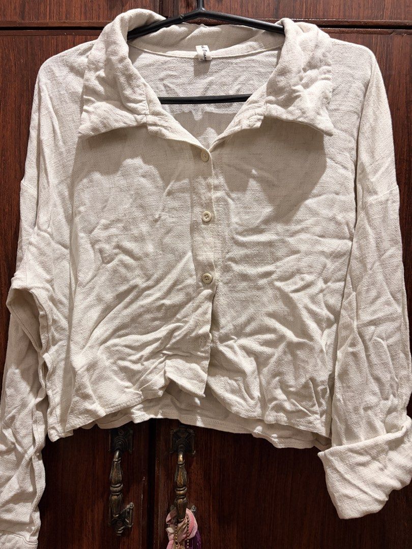 Cream Linen-like Collared Button-Up Shirt (Category: Shirts) located in Manila. Submitted by swiftdolphin.b7a9ae (Listing ID 1452011219, Image 1). Description: - Cream collared shirt - Button-up front - Long sleeves with rolled cuffs - Textured, linen-like fabric - Cropped style (hits above the waist) - Versatile: dress up or down - Pairs well with high-waisted bottoms Flaw: minor discoloration.