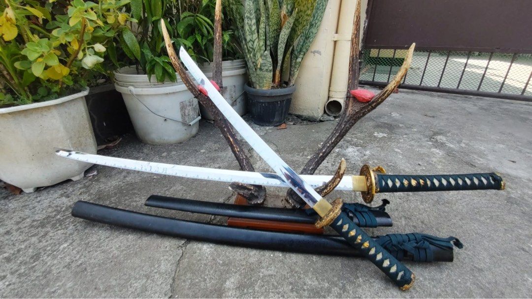 Decorative Katana Set (Category: Vintage Collectibles) located in Cainta. Submitted by danica010314 (Listing ID 1452036112, Image 2). Description: - Two decorative katanas included. - Features intricate designs on the blades. - Handles are wrapped in black. - Ideal for display or collection purposes..