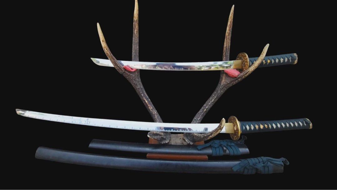 Decorative Katana Set (Category: Vintage Collectibles) located in Cainta. Submitted by danica010314 (Listing ID 1452036112, Image 1). Description: - Two decorative katanas included. - Features intricate designs on the blades. - Handles are wrapped in black. - Ideal for display or collection purposes..