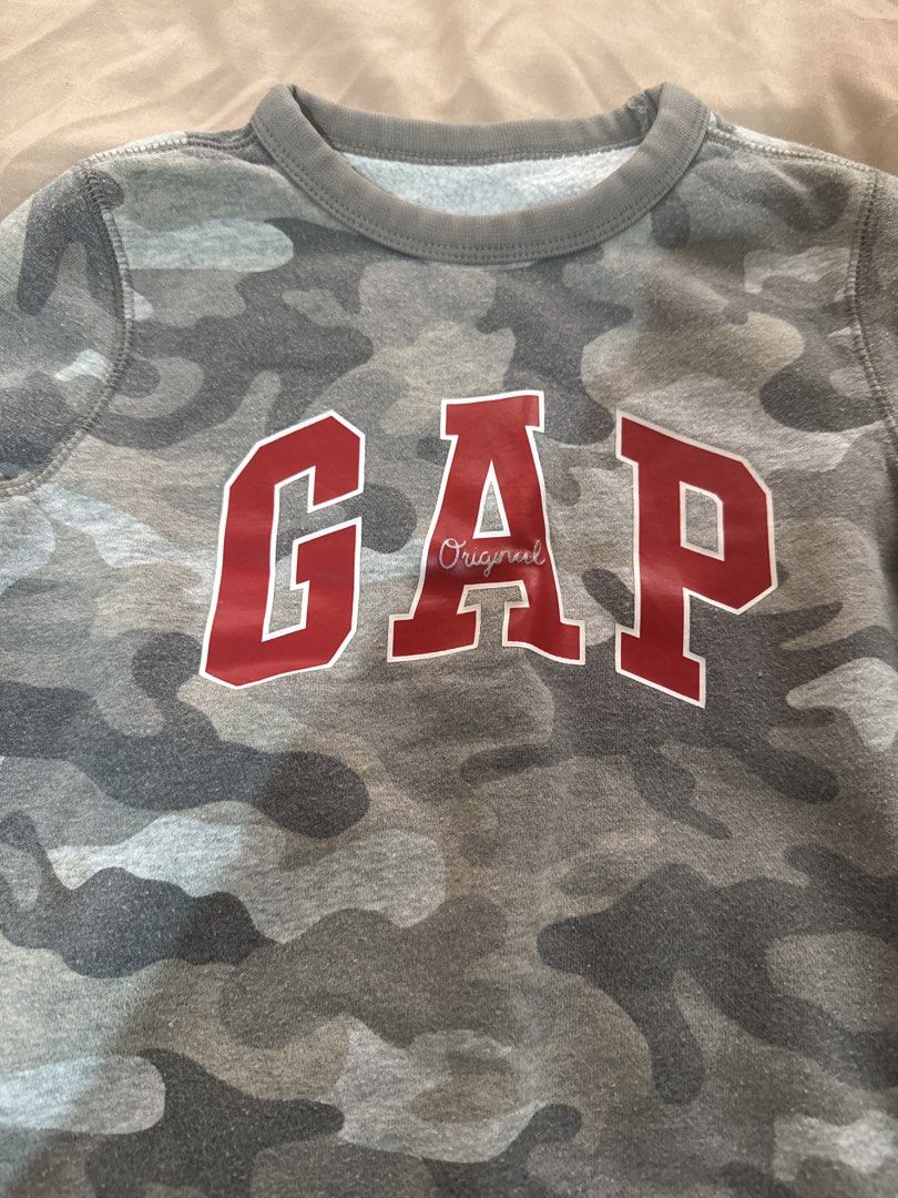 Gap Kids Camo Sweatshirt - Size XS (Category: Babies & Kids Fashion) located in San Pablo. Submitted by ShopbyLiz (Listing ID 1451900909, Image 1). Description: - Grey camouflage sweatshirt from Gap Kids - Features classic red Gap logo - Crew neck, long sleeves - Soft interior lining for comfort - Perfect for everyday wear - Size XS.