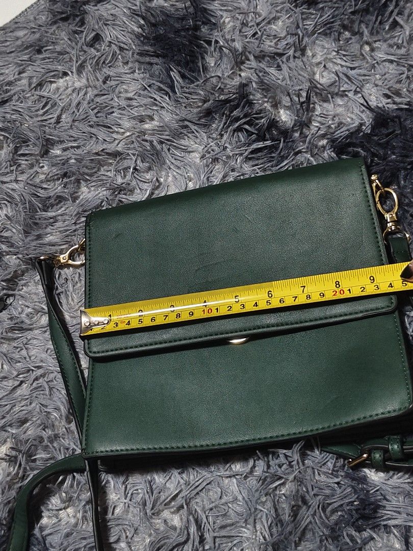 Green Crossbody Bag with Gold Hardware (Category: Luxury Bags & Wallets) located in Manila. Submitted by querobin11 (Listing ID 1452042417, Image 2). Description: - Stylish dark green crossbody bag - Secure flap closure with clasp - Multiple zippered compartments inside for organization - Adjustable and detachable strap for versatile wear - Elegant gold hardware details 240mm x 210mm - Please note: some wear on the edges, as pictured.