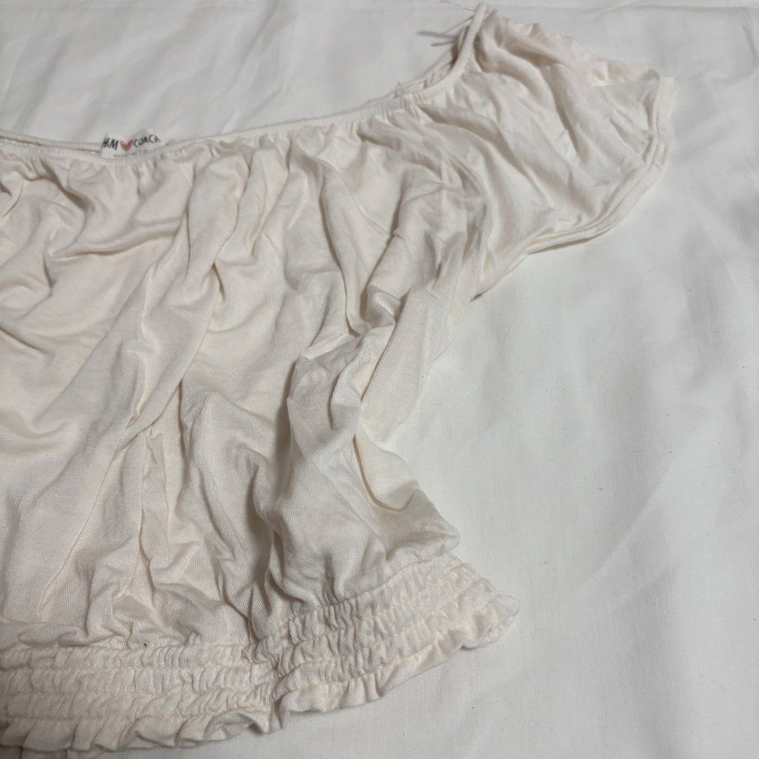 H&M Off-Shoulder Smocked Crop Top (Size: Large) (Category: Shirts) located in Manila. Submitted by shop.by.emi.cutie (Listing ID 1452040358, Image 2). Description: Brand: H&M Color: Cream / Off-White Size: Large (EUR L / US L) Style: Off-shoulder milkmaid / boho crop top Details: Elasticized neckline and short cap sleeves Ruched / gathered front detail Smocked elastic hem Soft and stretchable knit fabric Great for: Summer, casual wear, beach wear