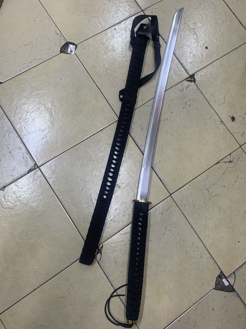 Katana Sword with Scabbard and Strap (Category: Vintage Collectibles) located in Pasig City. Submitted by wild_rex_blaza (Listing ID 1451970761, Image 1). Description: - Black handle katana sword - 33 inches all black, with gold colored plate and leather strap - Silver metal blade - Comes with a black scabbard - Includes an adjustable strap - Ideal for display or collection - Serious buyers only.
